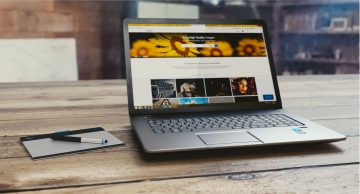 A laptop running Windows sits on a desk with a drawing tablet