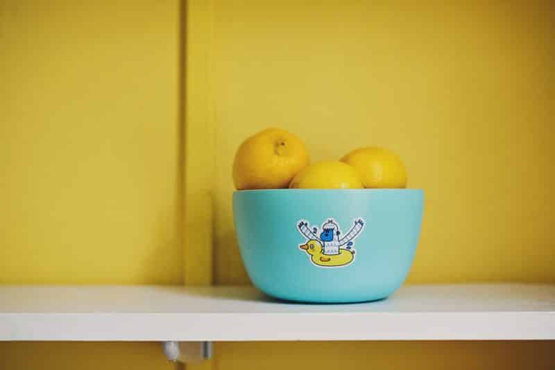 A friendly monster sticker on a blue bowl full of lemons