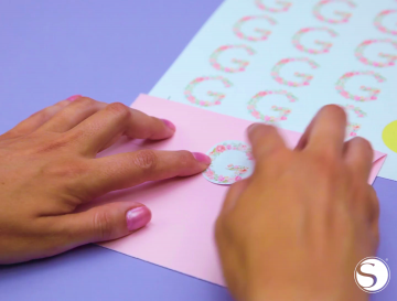 A woman places the sticker to seal an envelope