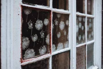 White snowflakes decorate the interior of a rustic window