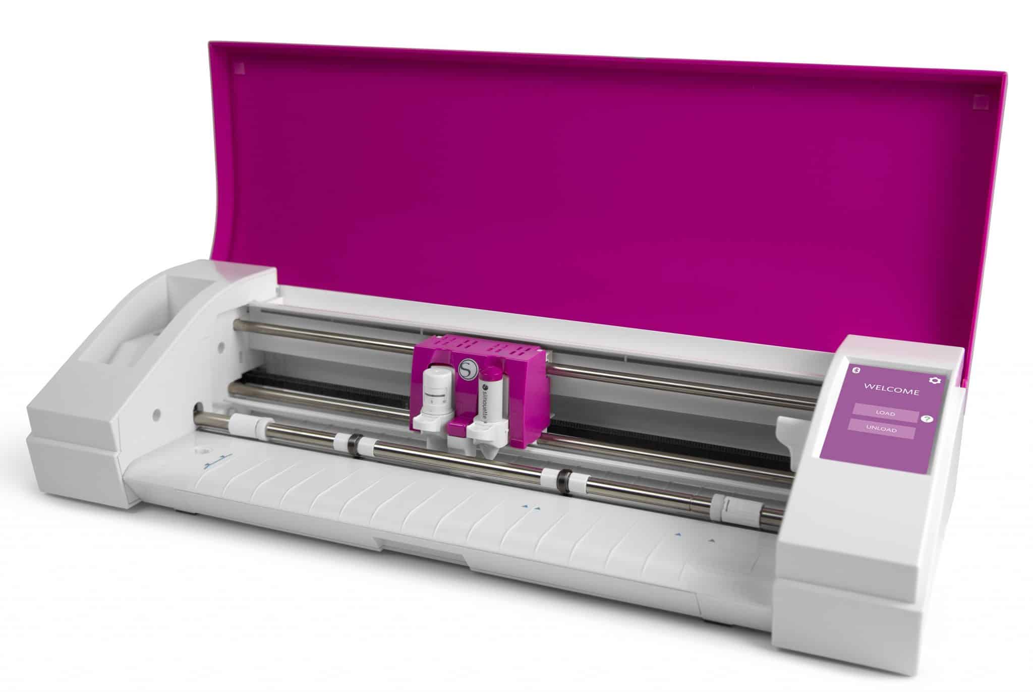 A bright pink Cameo 3 sits with the lid open, showing off the cutting head and tool holder.