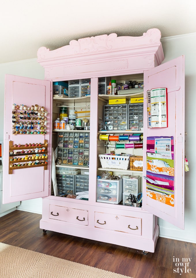 Antique armoire filled with perfectly organized sewing supplies